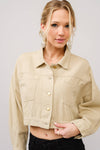 Woman wearing a beige jacket against a plain background