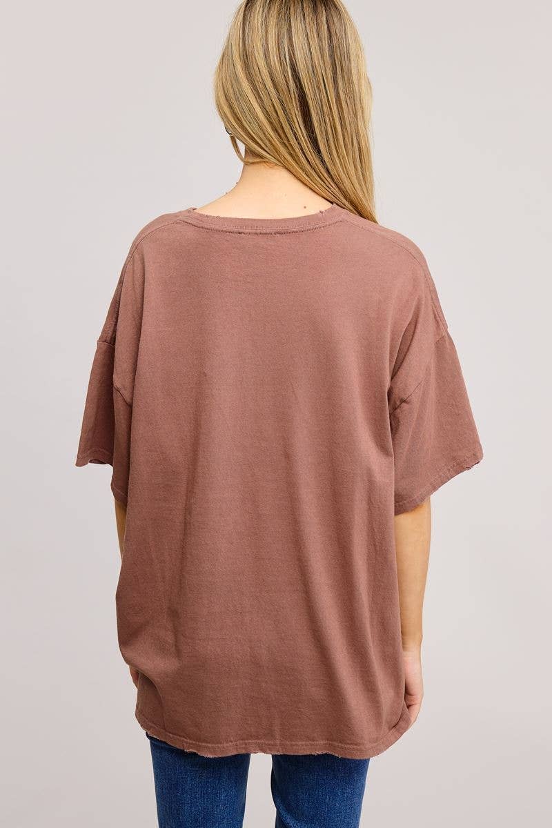 Person wearing a brown oversized t-shirt on a plain background