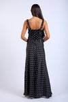 Woman wearing a black polka dot dress on a white background