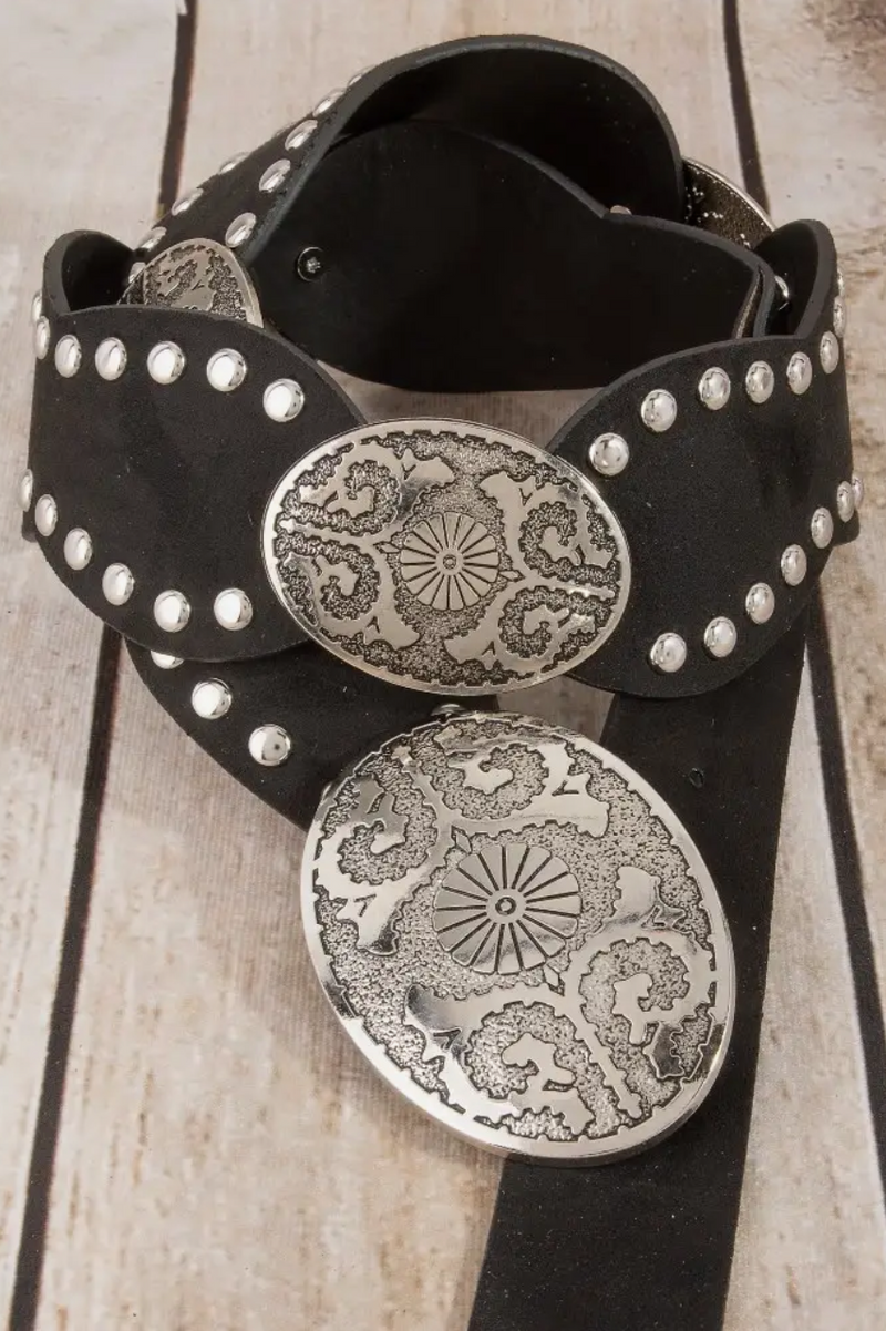 Black belt with silver floral embellishments on a wooden surface