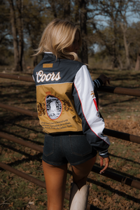 Person wearing a Coors branded jacket in an outdoor setting
