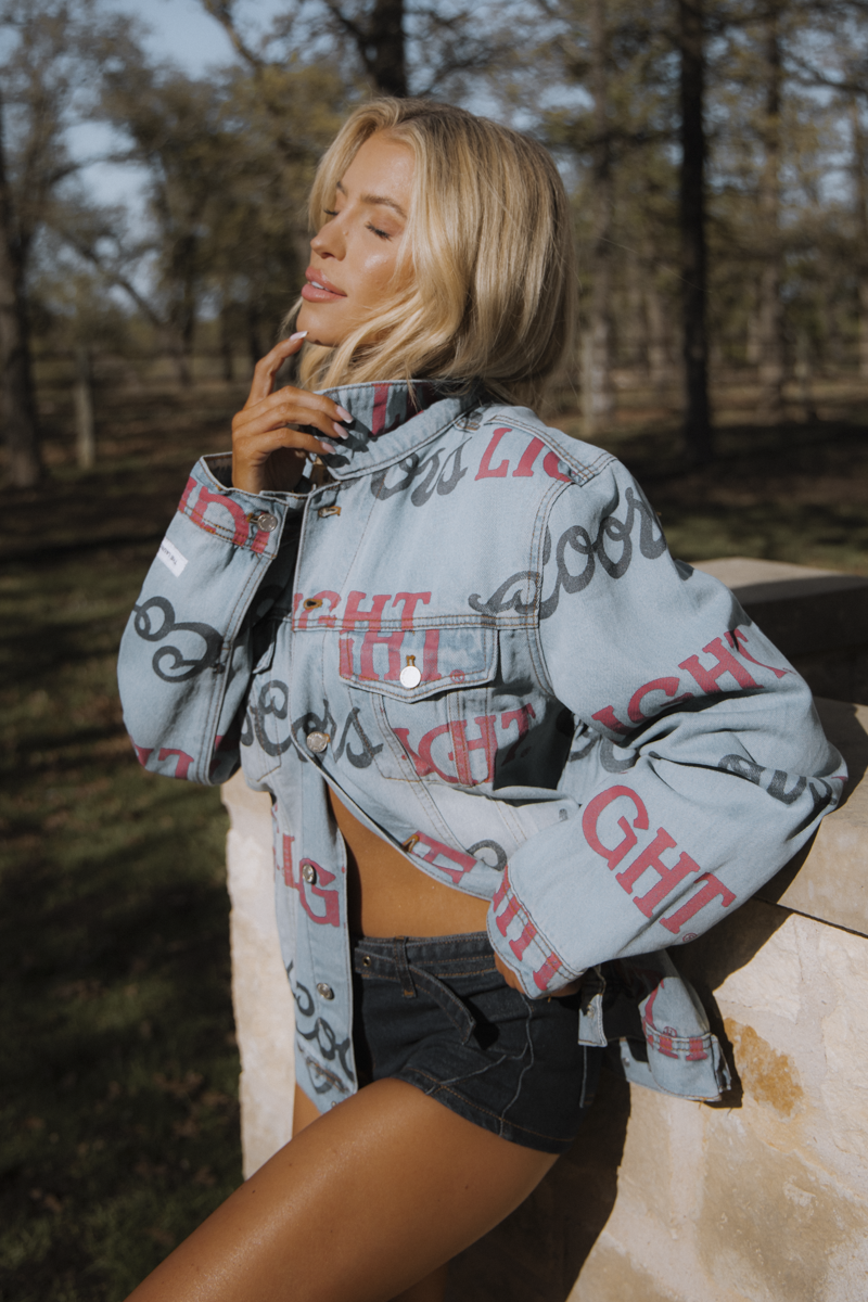 Woman wearing a denim jacket with text pattern outdoors