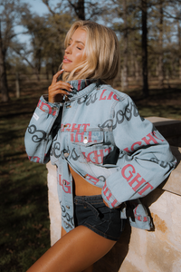 Woman wearing a denim jacket with text pattern outdoors
