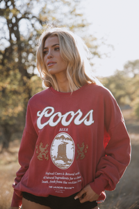 Person wearing a red Coors beer sweatshirt outdoors