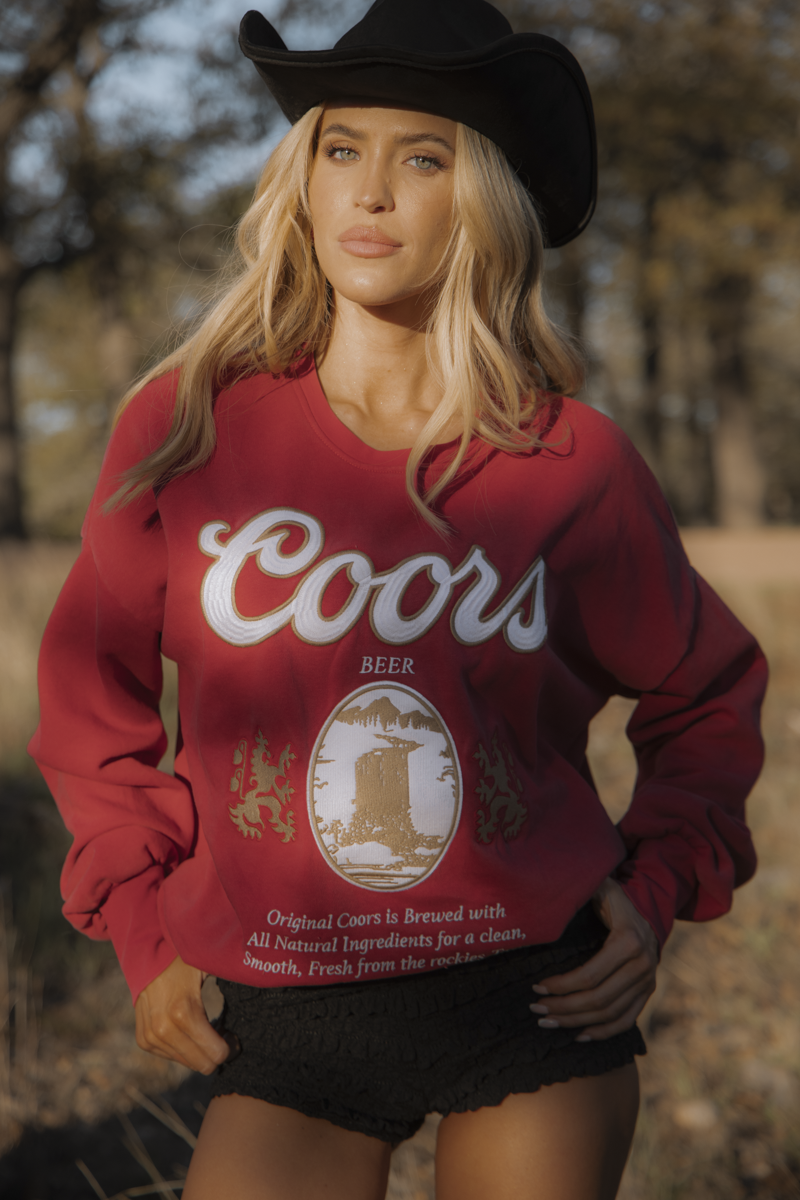 Person wearing a red Coors sweatshirt outdoors