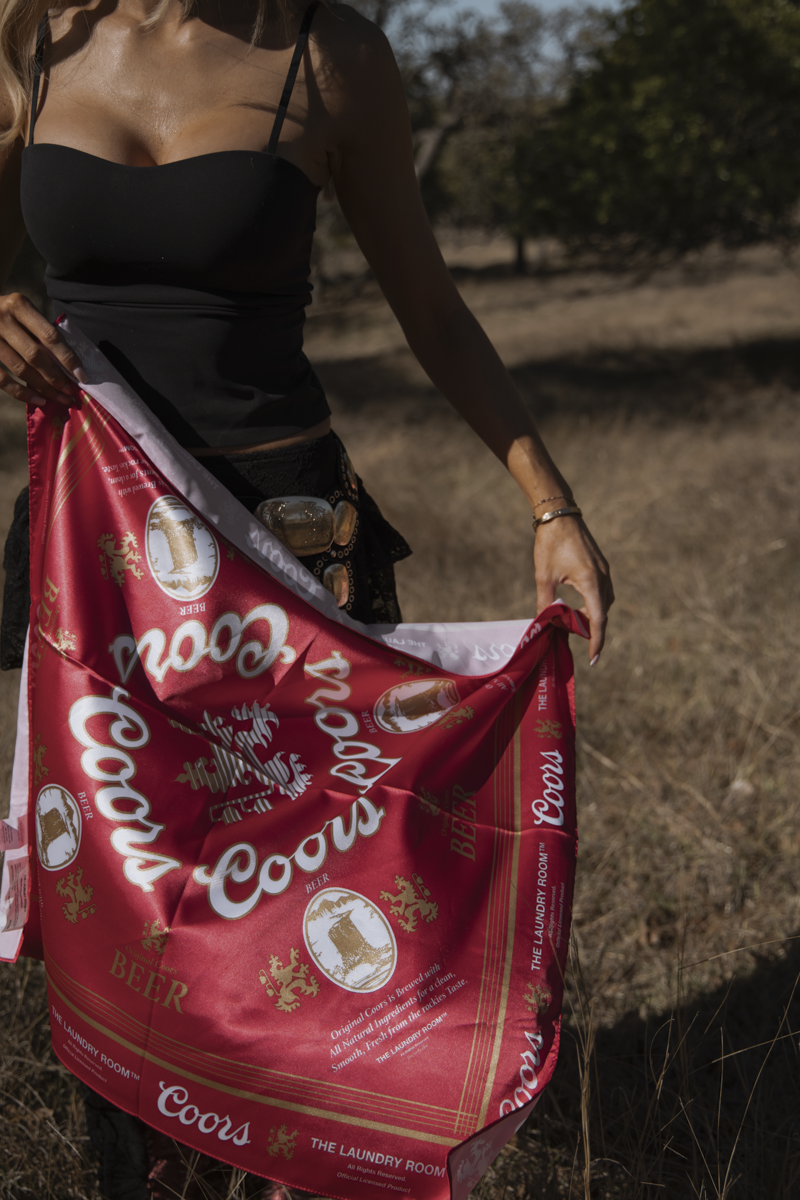 Person holding a Coors beer bag in a natural setting