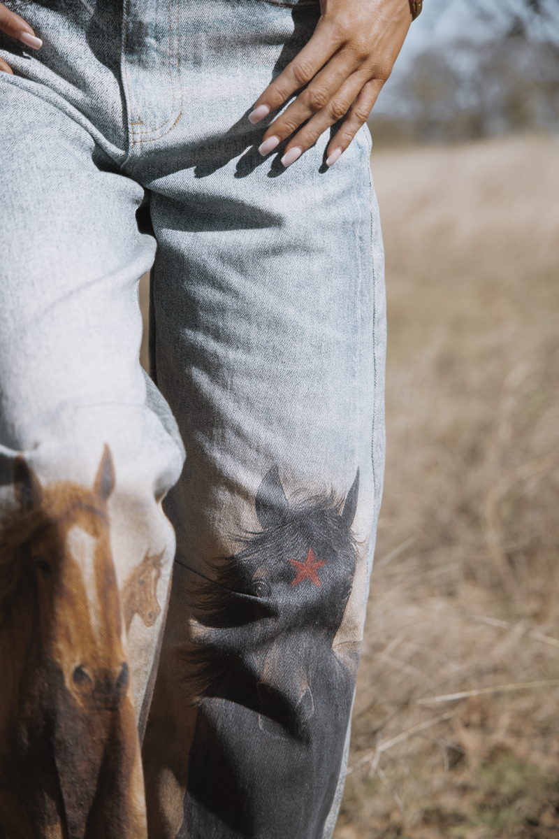 Person wearing a hoodie with horse print in a natural setting
