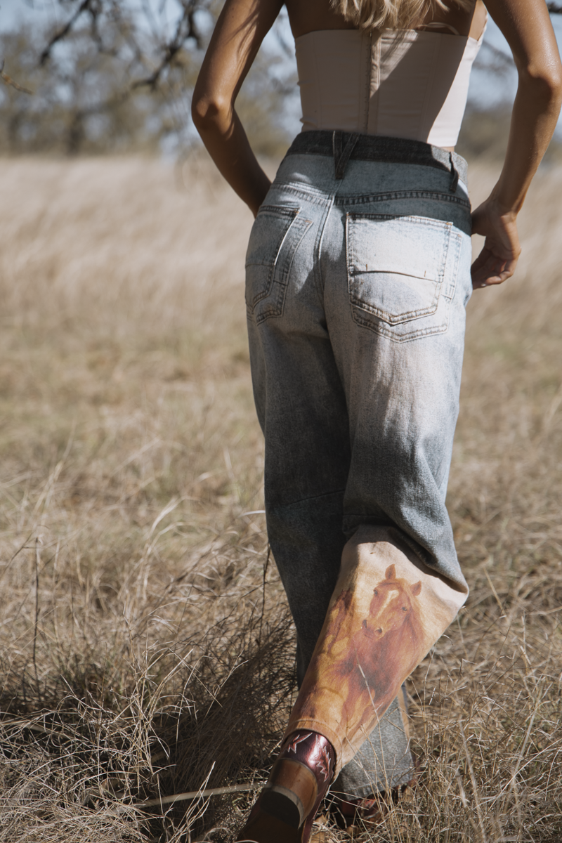 Person wearing a unique outfit with a long, patterned sock walking through a field.