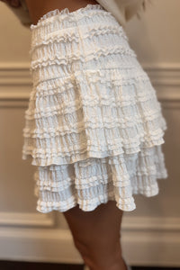 Close-up of a tiered ruffled skirt with a neutral background
