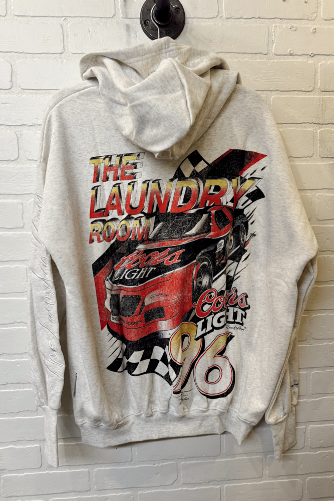 Gray hoodie with a colorful graphic design on a brick wall background