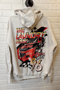 Gray hoodie with a colorful graphic design on a brick wall background