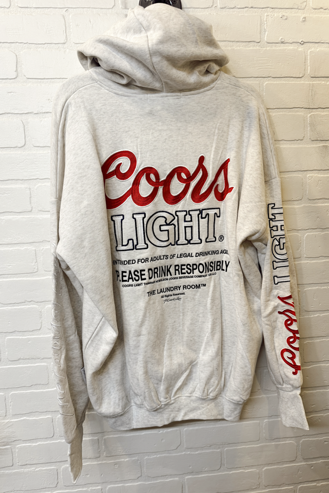 Gray hoodie with Coors Light branding on a white brick wall