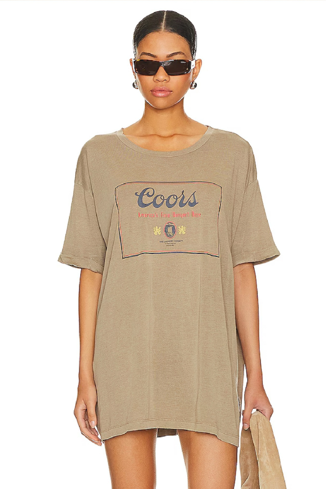 Woman wearing a brown t-shirt with a Coors logo on a white background