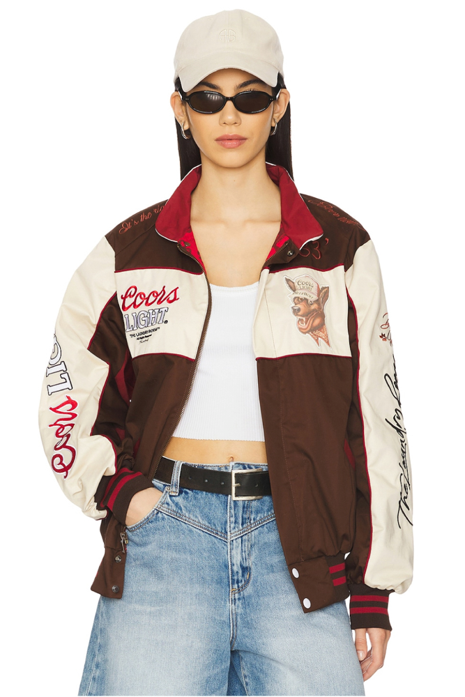 Person wearing a patterned brown and beige jacket with visible Coors branding in red black and white