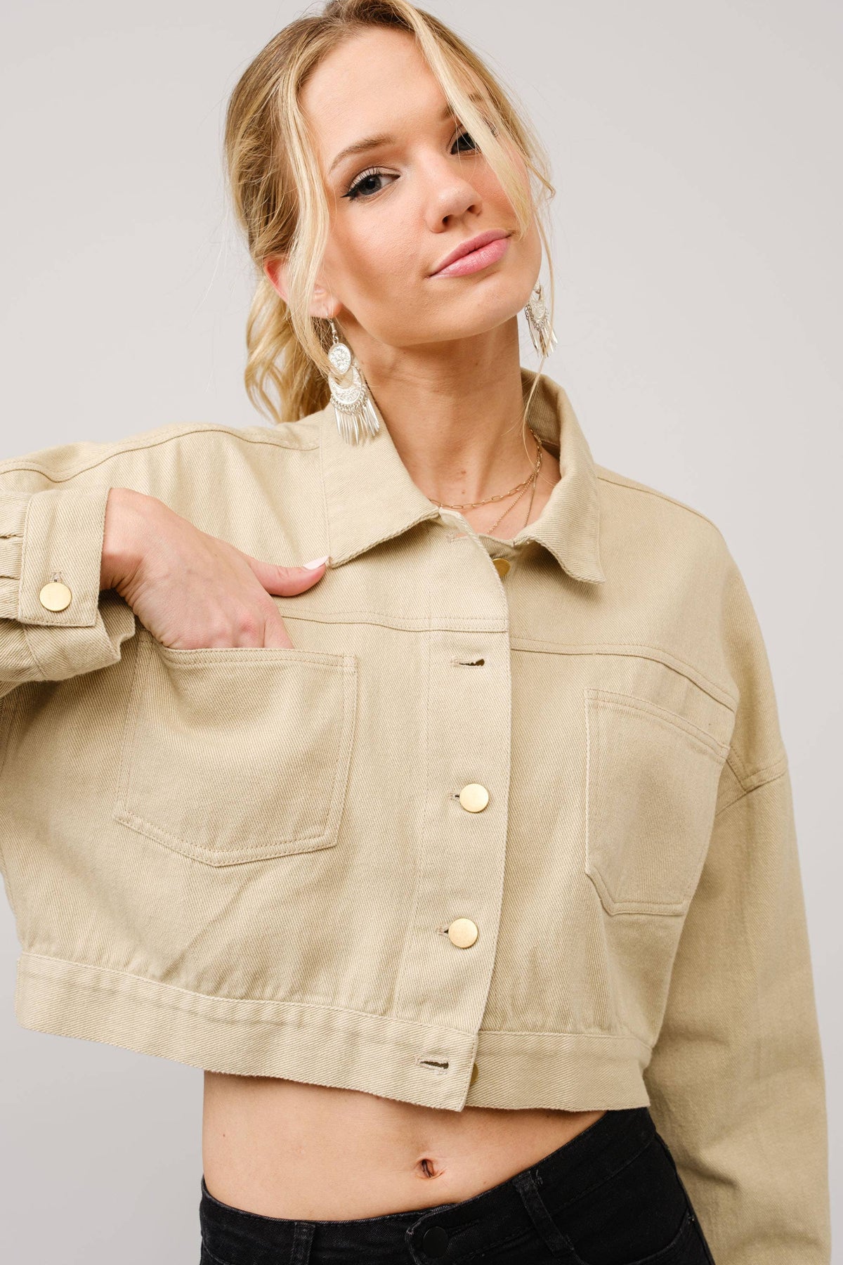 Woman wearing a beige jacket with a plain background