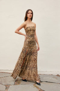 Woman wearing a leopard print strapless gown against a plain background